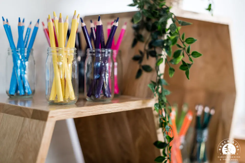 Pencils and art materials ready on a timber easel at Beach Kids Cabarita