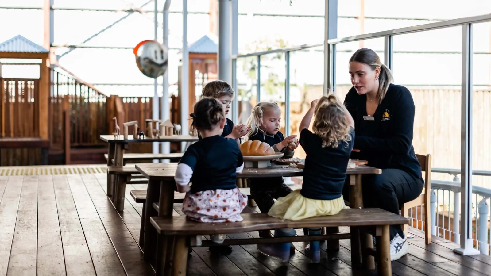 Children eating together at outdoor timber tables at Chinderah