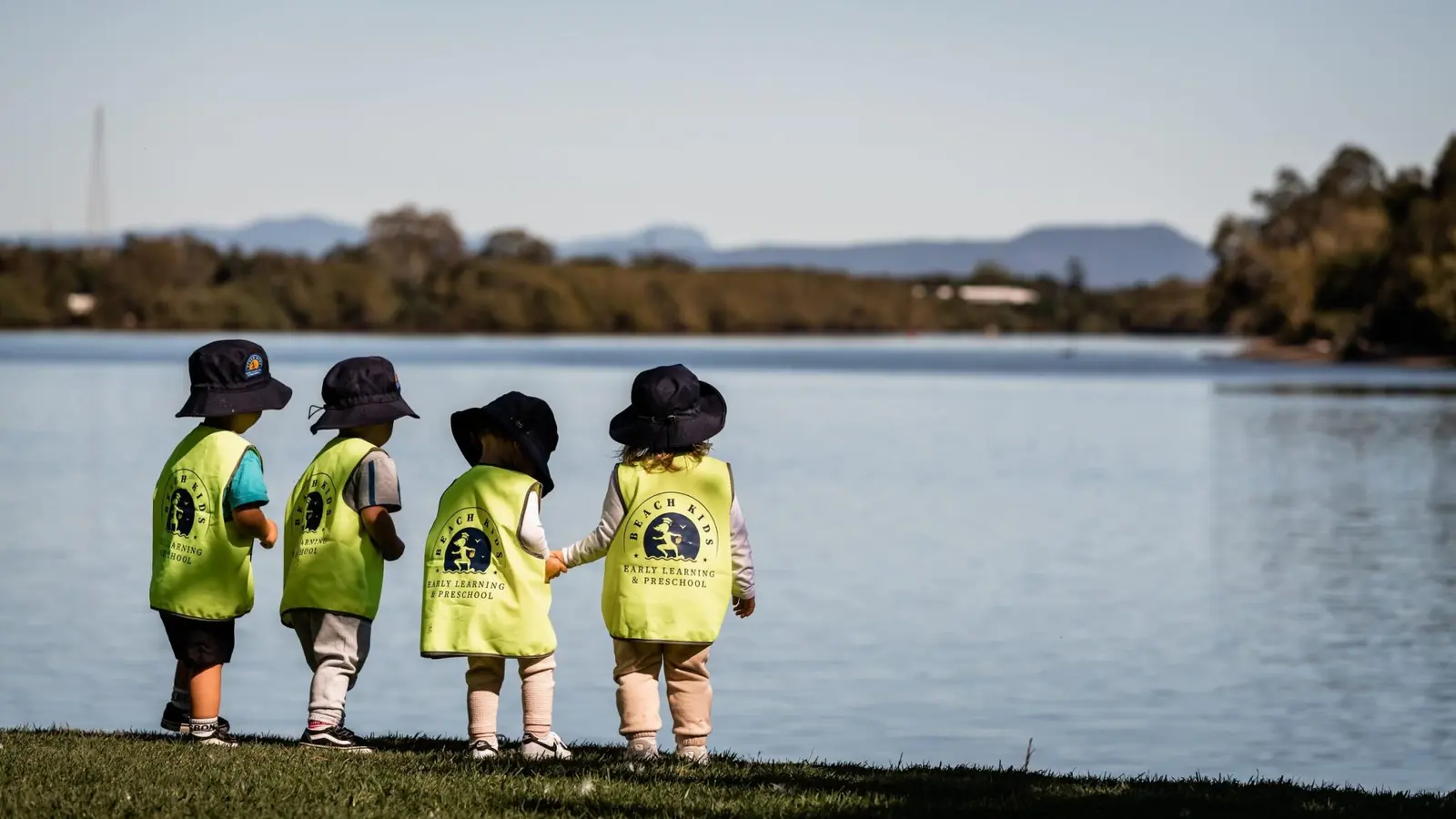 Children in hi-vis vests looking out over the water on an excursion