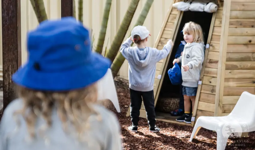 A child climbing a natural timber structure outdoors