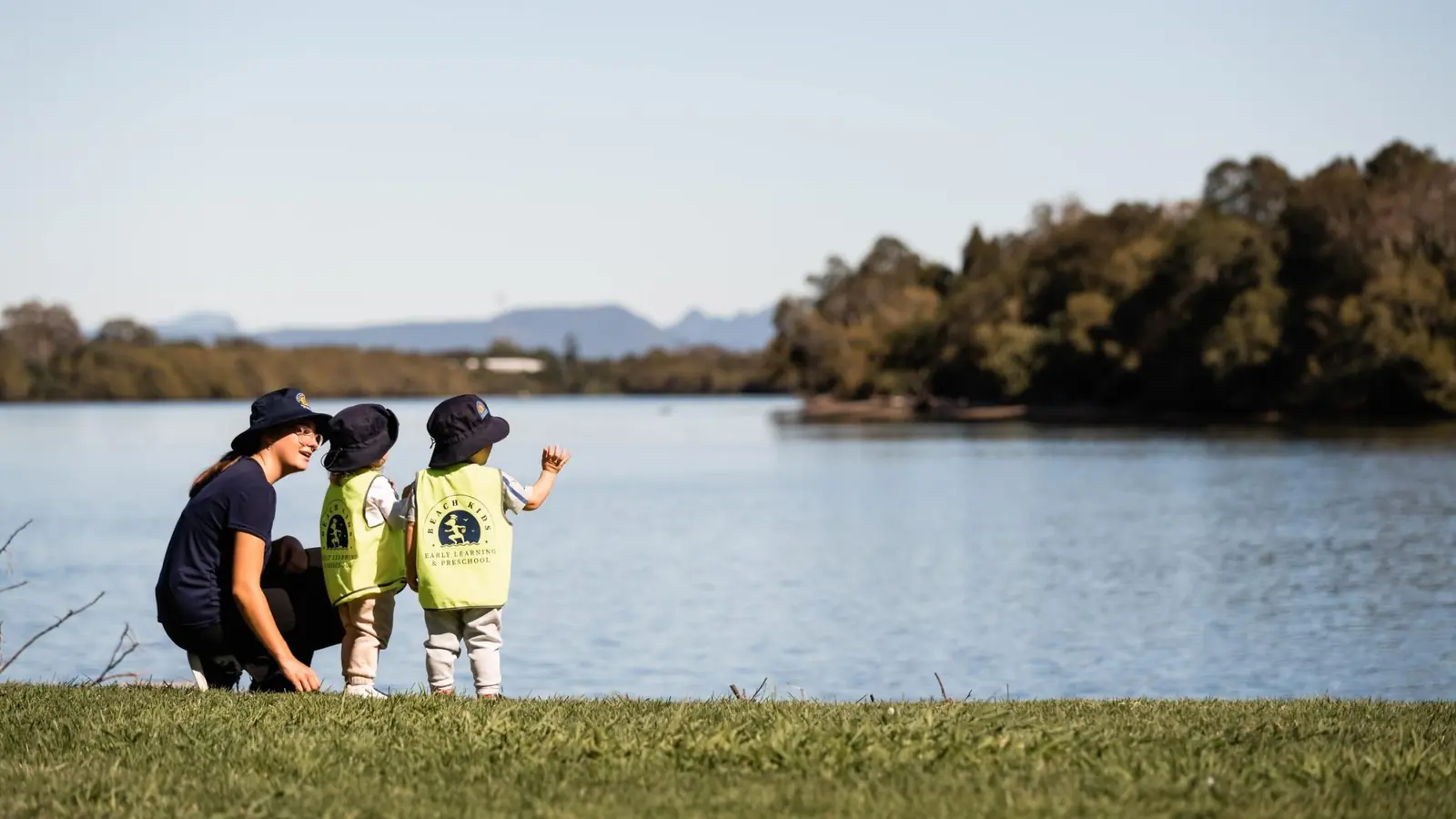 Two children exploring the shoreline with an educator
