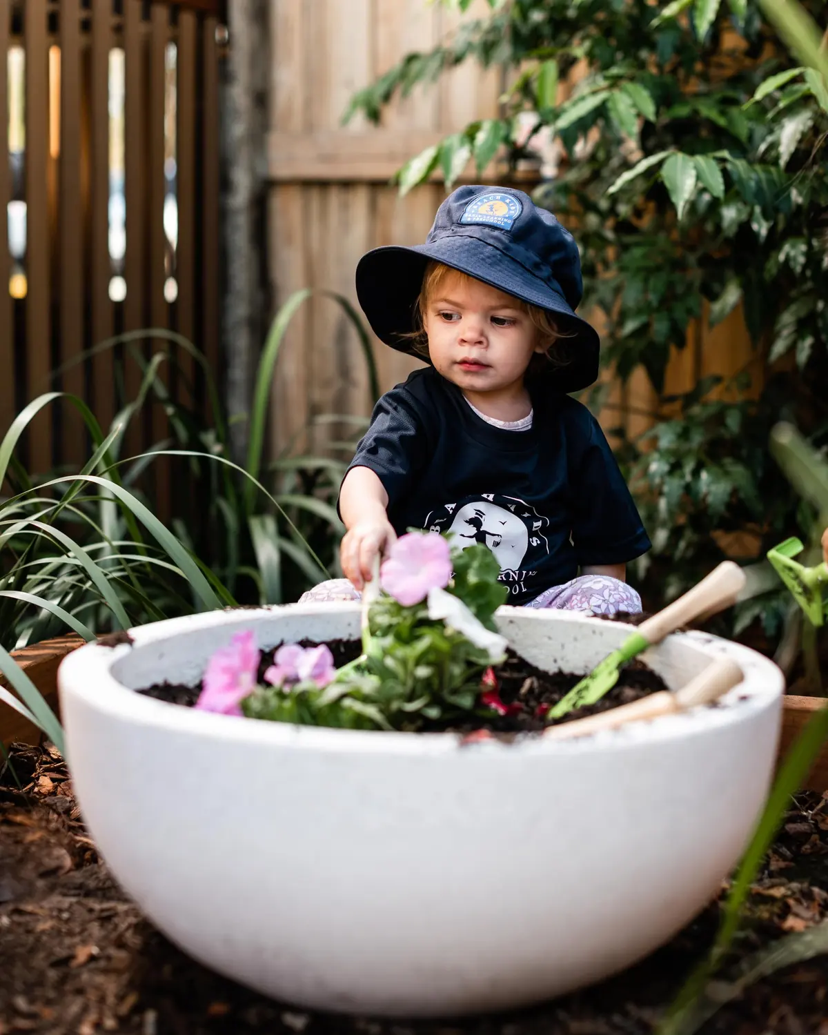 A child planting seedlings in a garden bowl at Chinderah